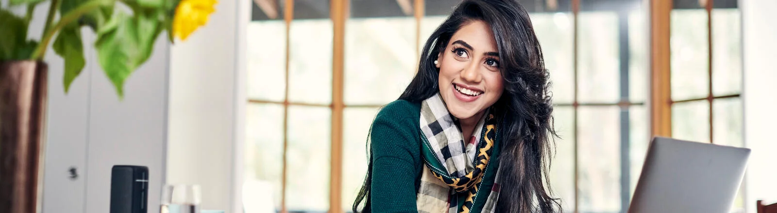 Deakin master of international relations student sits and smiles at desk on campus.