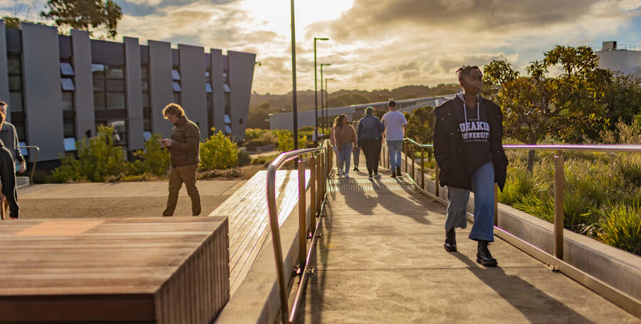 Deakin students walk around the Warrnambool Campus at dusk.