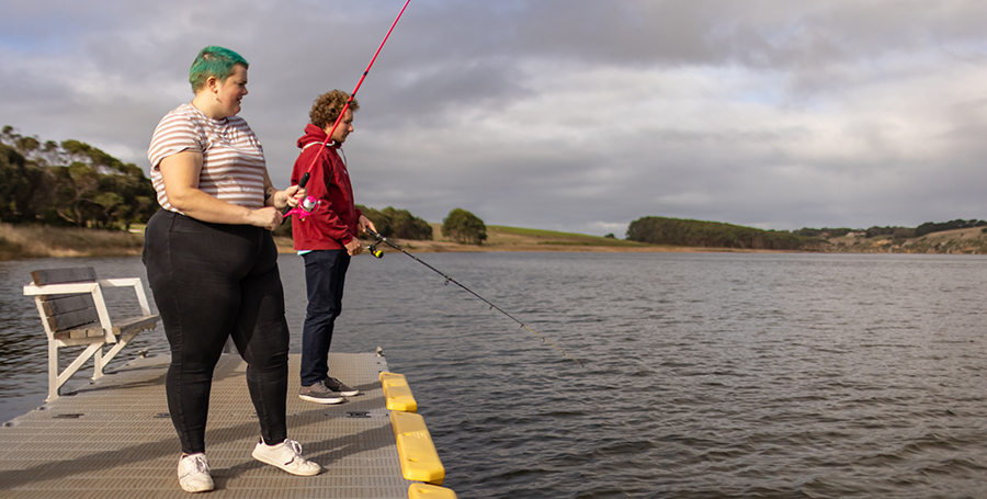 Two students fishing on a dock