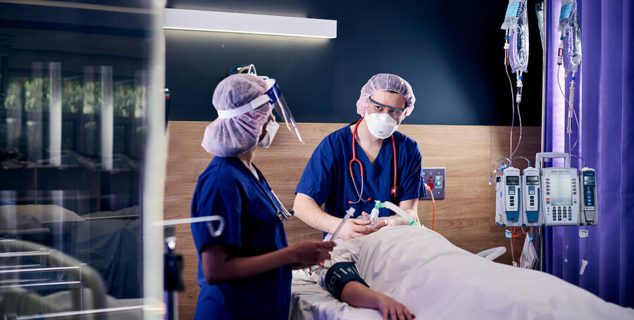 Two students with a nursing simulation patient.
