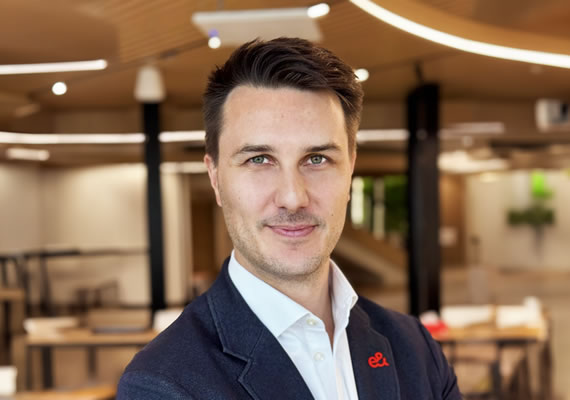 Headshot of Michael Filius, wearing a suit shirt and branded company jacket.