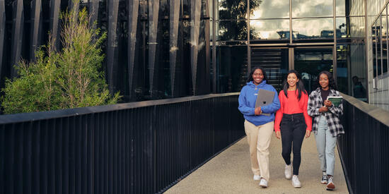 A group of students walking along the bridge at Burwood campus.