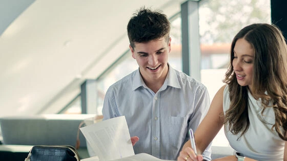 Two Deakin bachelor of business / criminology students work together on campus