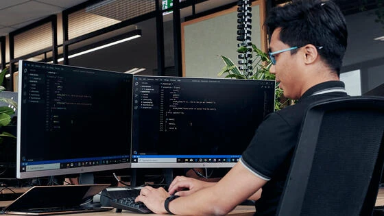 Deakin doctor of philosophy information technology student working at computer on campus.