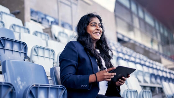 A Deakin master of business sport management sits in a stadium. 