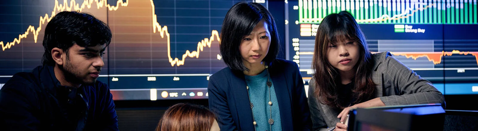 Business analytics students engaging with stock market feeds in the DBS trading room.