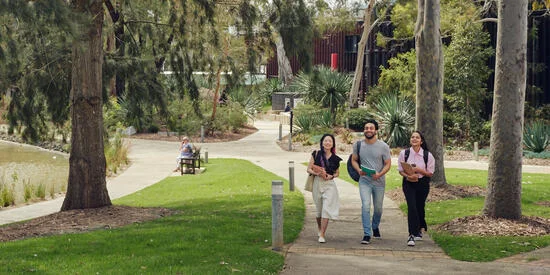 Two Deakin studentsThree students walking past a pond on the picturesque Geelong Waurn Ponds campus sit on a wall at Deakin's Geelong Waurn Ponds Campus.