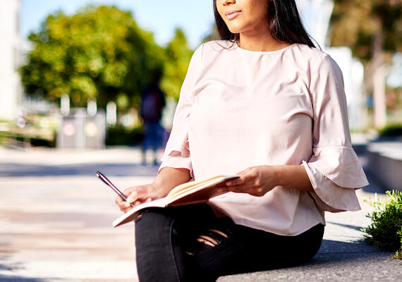 A person reading a book outside.