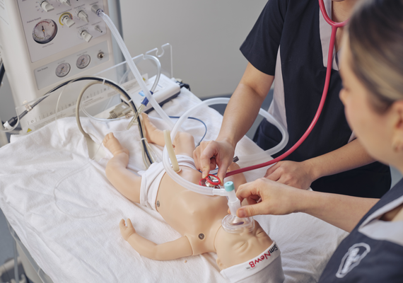 Two nursing students working on an infant simulation.
