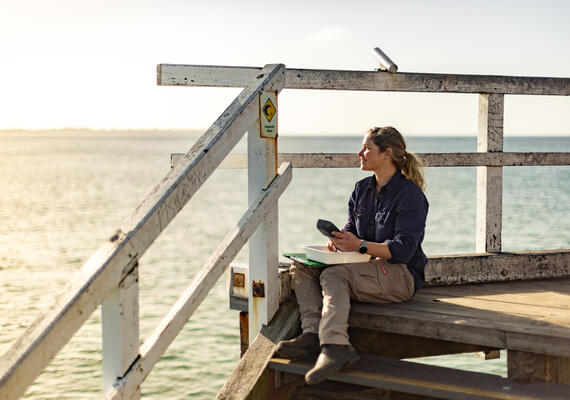 Deakin marine science student at pier next to the ocean for research.