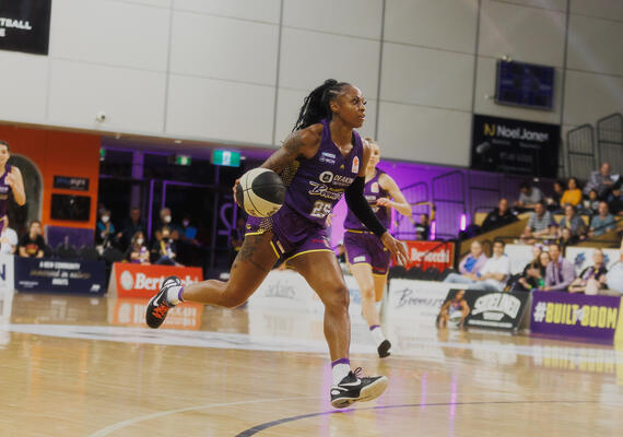 Boomers players playing basketball on a court.