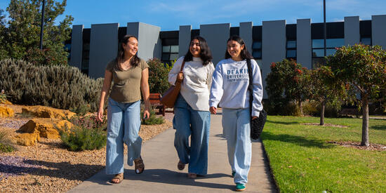 Three Deakin Res students walk along a path at the Warrnambool