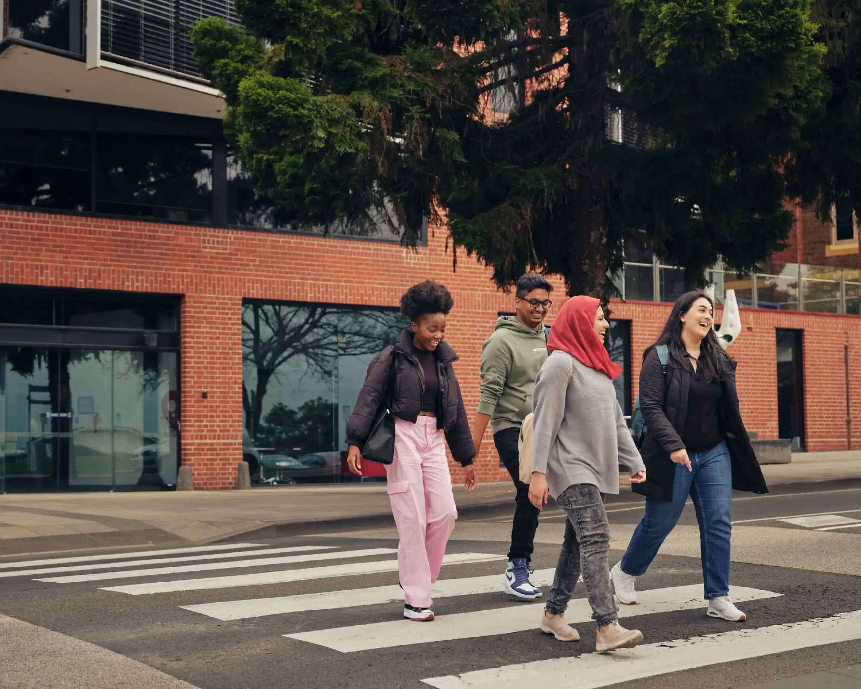 Four Deakin students crossing the road at Waterfront Campus