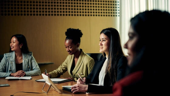 Three Deakin postgraduate recruitment students sit at a desk.