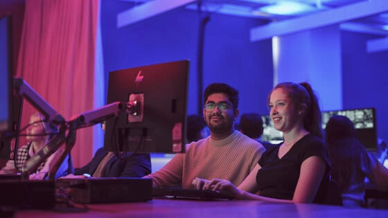 Two deakin bachelor of cyber security honours students work on computers on campus.