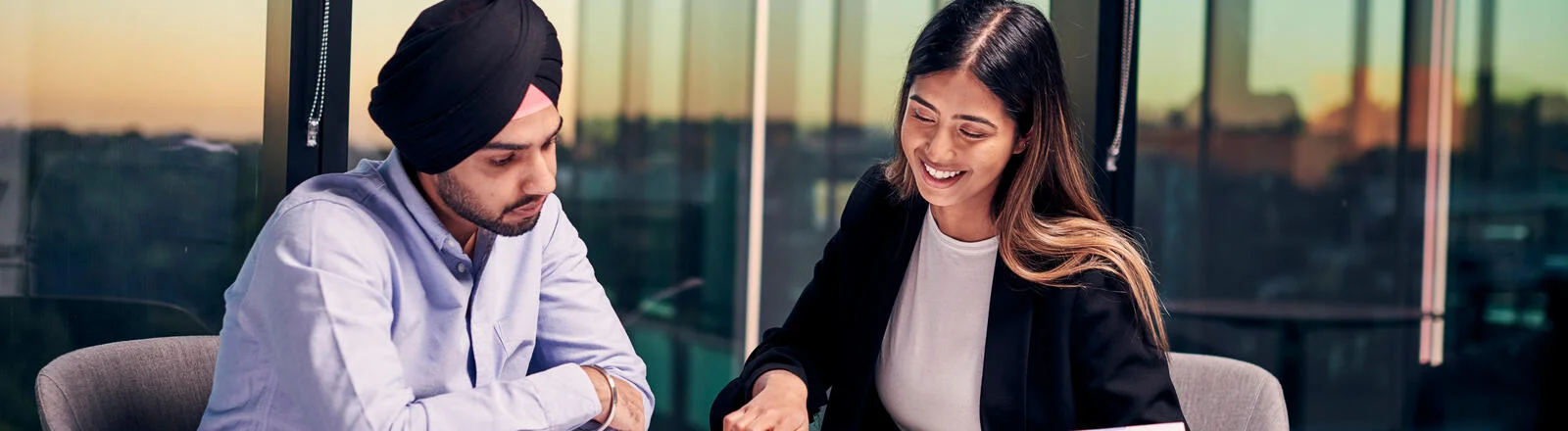 Two Deakin graduate diploma of financial planning students sitting at a table and talking.