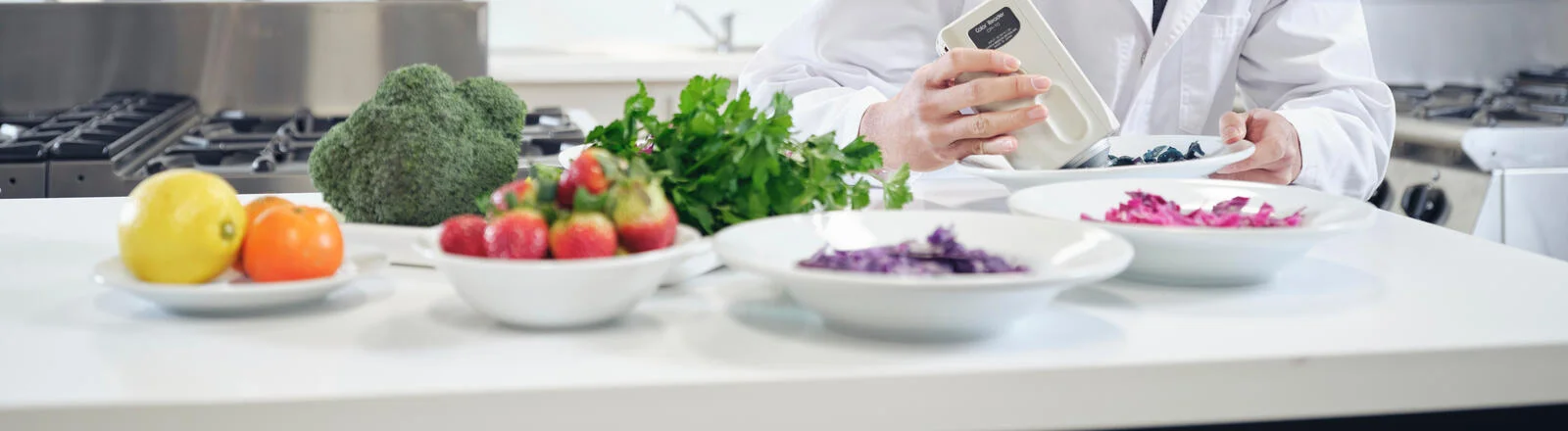 Deakin graduate diploma of human nutrition student performs tests on different bowls of food in lab.