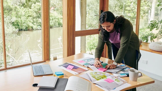 Deakin graduate diploma of land and sea country management student studies plans and works in house along a river.