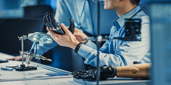 An engineering student working on a robotic hand