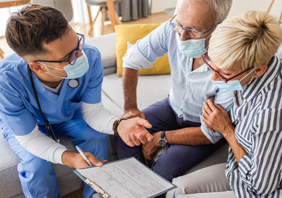 A nurse helps two people go through a form 