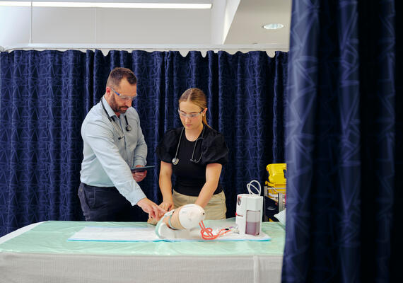Student in the clinic examining a patient.