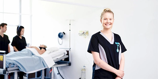 Deakin nursing student posing for camera in scrubs.