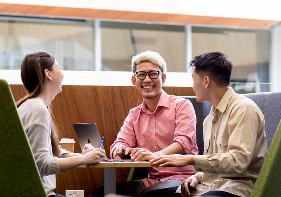 Three Deakin students sit in open study area with laptops.