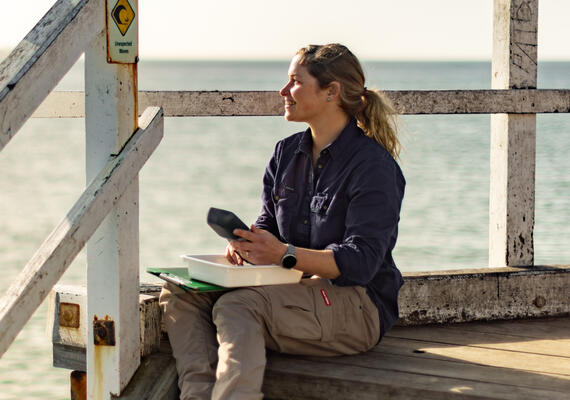 Water management researcher sitting next to lake