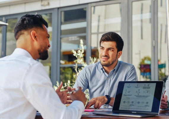Two Deakin students with a laptop having a discussion.