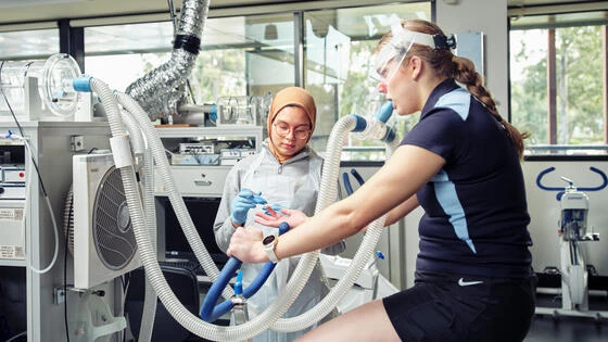 A Deakin bachelor of exercise student on a bike monitored by medical equipment.
