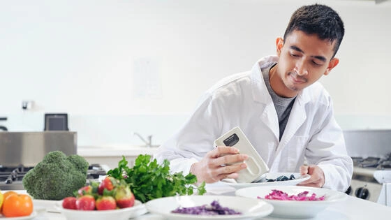 Deakin graduate diploma of human nutrition student performs tests on different bowls of food in lab.