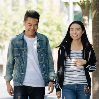 Two students walking and laughing