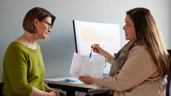 Deakin master of mental health nursing student talks to patient in clinic office.