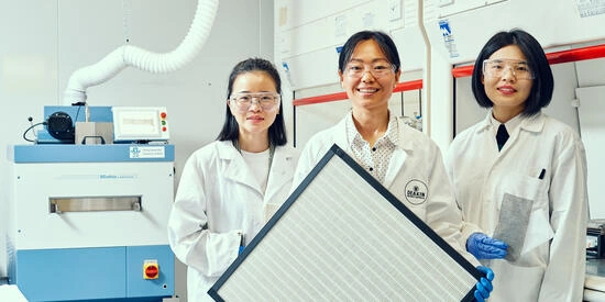Deakin researchers standing in a lab holding a filter.