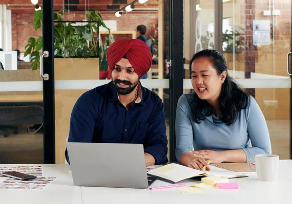 Two students working together a desk at the Deakin Burwood Campus