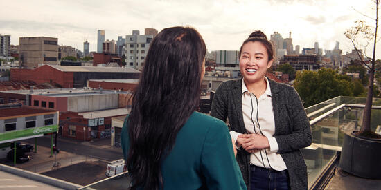 Master of Communication students smile while talking.
