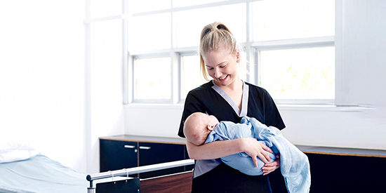 A Deakin midwifery student holds a baby 