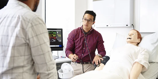 A student doctor with a nursing simulation model.