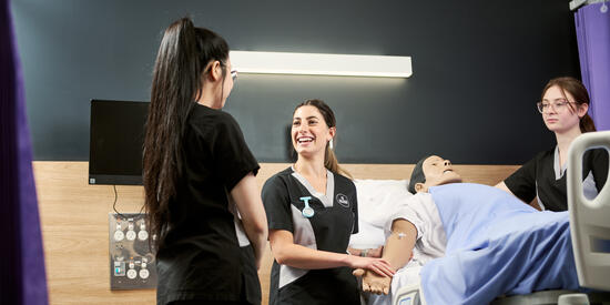 Two students with a nursing simulation model.