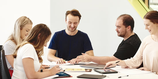 Deakin students sitting around a table, studying together.