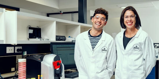 A research students and supervisor smile in the lab