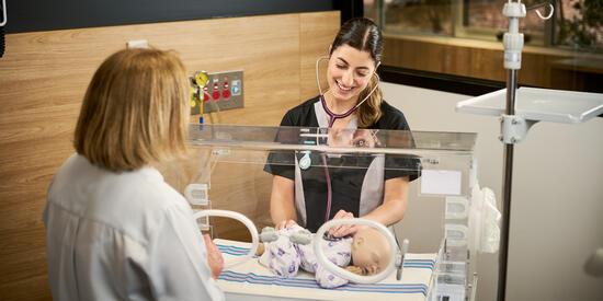 A midwifery student examines a model baby