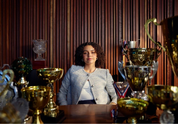 Person sitting in trophy room looking at camera