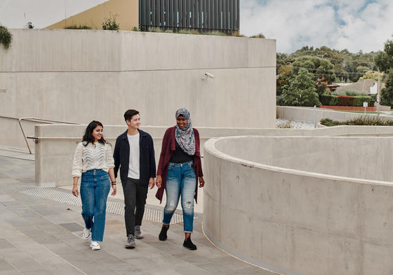 A group of three students walking through campus. 