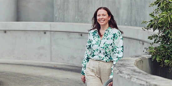 A happy Deakin student walking up a ramp on campus