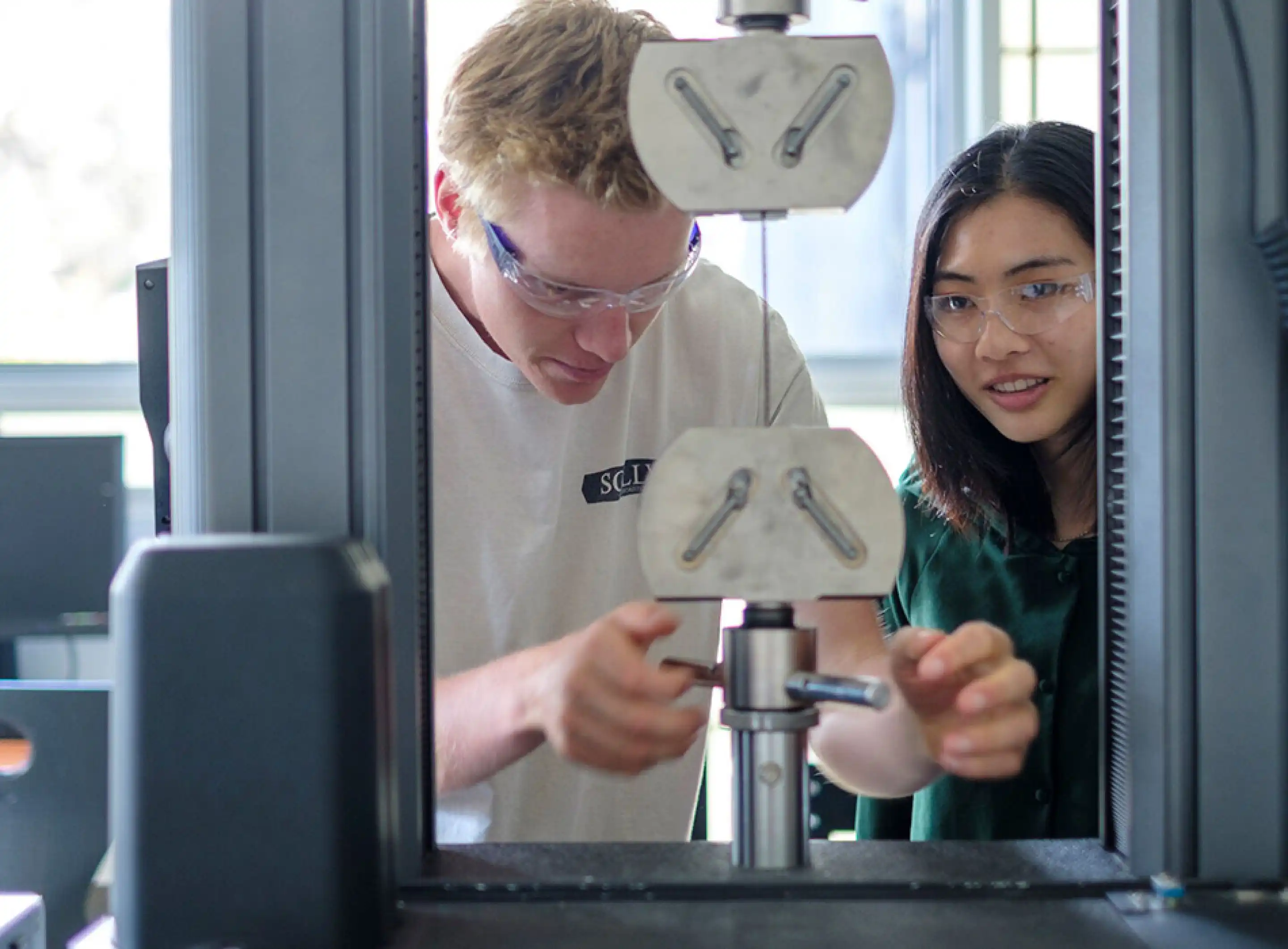 Two students using machine in engineering lab