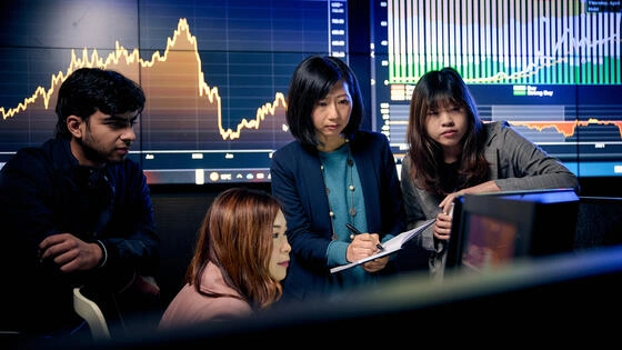 Business analytics students engaging with stock market feeds in the DBS trading room.