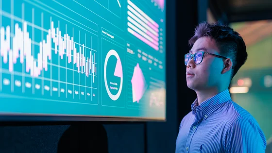 Business analytics student reviewing data on a big screen.