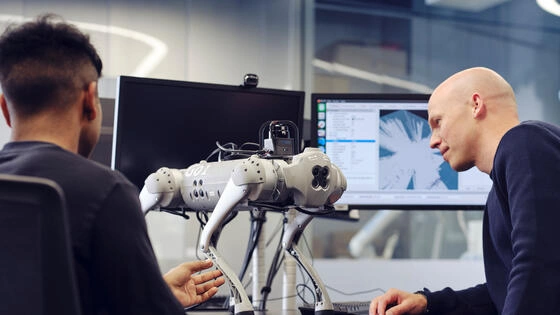 Two Deakin master of applied artificial intelligence professional students work on a robot in a lab.
