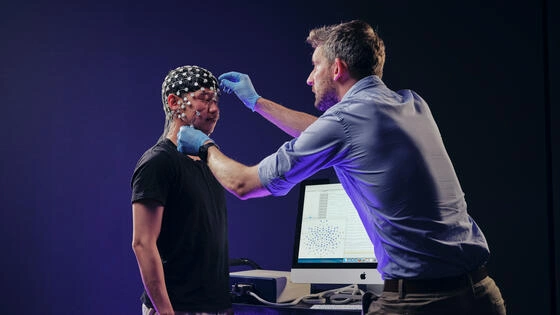 Deakin graduate diploma of psychological science student performing tests on someone in a campus lab.